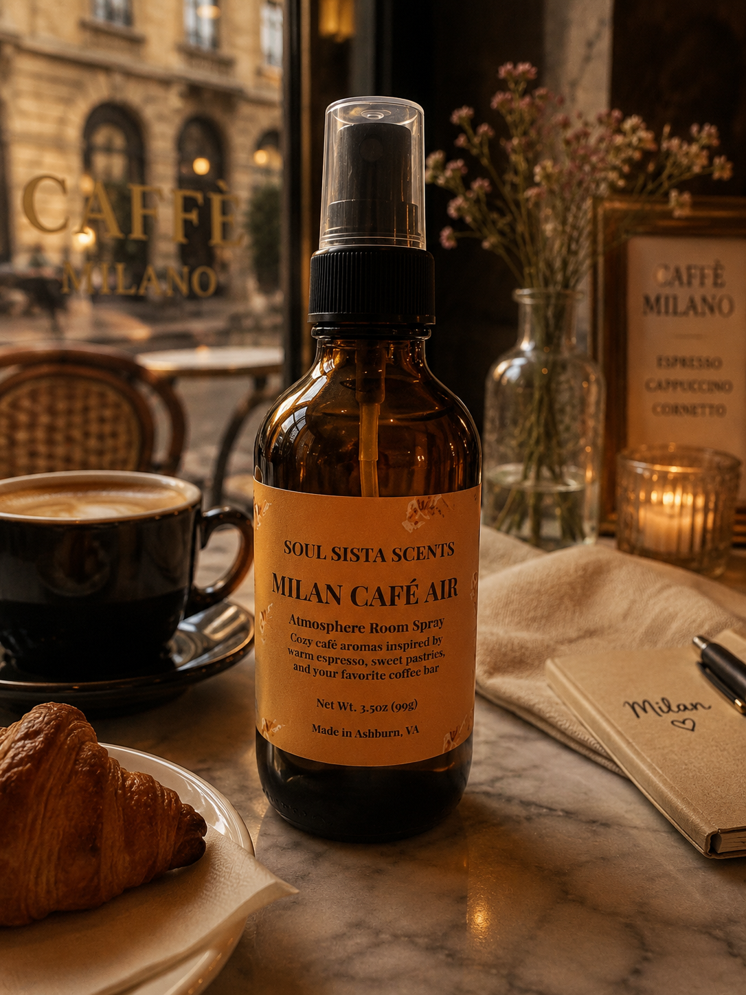Soul Sista Scents Milan Cafe Air room spray amber bottle on a marble table styled with coffee and a croissant
